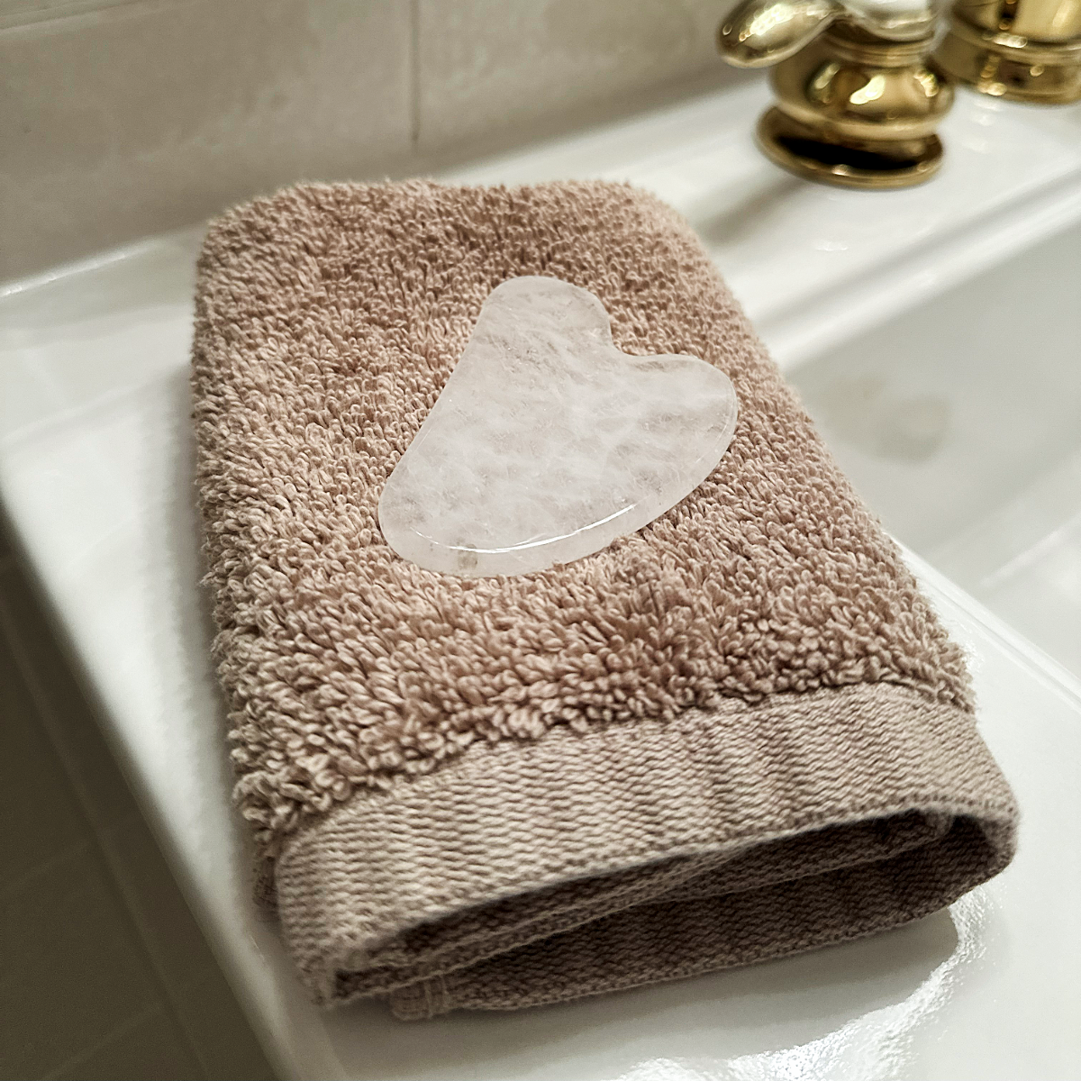 Gua Sha Tool, white, on towel, edited SQUARE